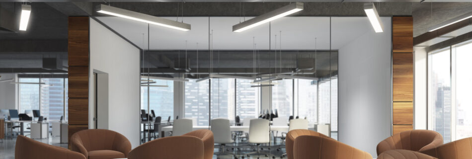 Moderne kontorlobbby med brune lesestoler, glassvegger og LED-belysning fra tak.